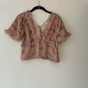 Anthropologies beaded top with tiny buttons on front and tie in the back.